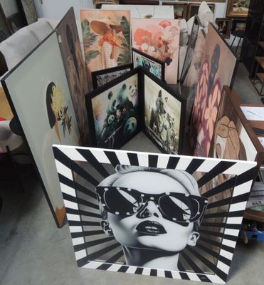 a lot of paintings that are on display in a room