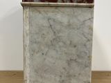 a marble box on a wooden table with a white wall in the background