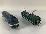 two toy trains sitting side by side on a white surface