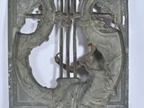 a metal plaque with a woman playing a musical instrument