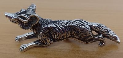 figurine de chat plaquée argent posée sur une table en bois