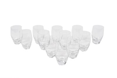 six verres à vin transparents alignés sur une surface blanche