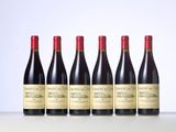 six bottles of wine are lined up on a table