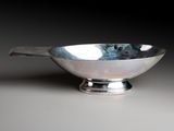 an image of a silver bowl with a handle on a table