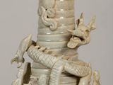 a white vase with a dragon on top of it