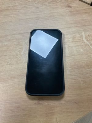 un téléphone portable posé sur une table, avec un bout de papier dessus
