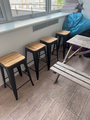 four stools and a table in the corner of a room