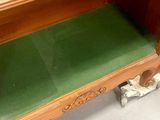 a wooden desk with a green cushion underneath it