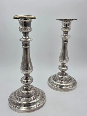 Une paire de bougeoirs en métal argenté, à décors ciselés de…