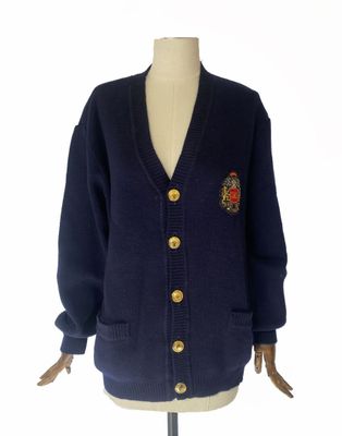 un cardigan bleu marine à boutons dorés sur un mannequin