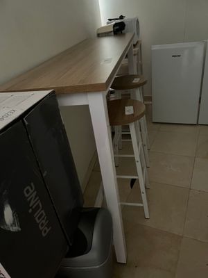 une petite cuisine équipée d'un réfrigérateur et d'une petite table