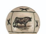 a plate with a bull on it on a white surface