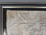 an old document with writing on it is hanging on a wall