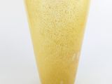 a yellow glass vase sitting on a white surface