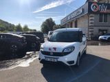 the small white van is parked in front of a building