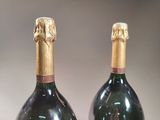 two bottles of champagne sitting next to each other on a table