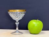 a green apple next to a wine glass on a table
