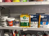 de nombreux pots de peinture sur une étagère dans un magasin