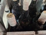 many bottles of wine in a metal basket on a table
