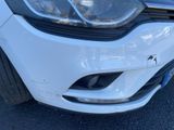 the front end of a white car with a denting bumper