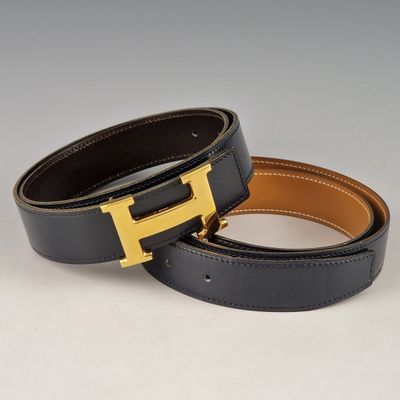 a pair of black and brown leather belts with a gold h buckle