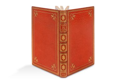 un livre rouge avec des bordures dorées et un nœud sur le dessus