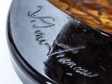 a close up of a glass bowl on a black plate