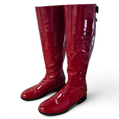 pair of red boots on a white surface with a white background