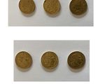 quatre types différents de pièces d'or sont présentés sur une surface blanche