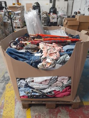 a cardboard box full of clothes and other items in a warehouse