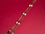 a close up of a necklace on a red surface