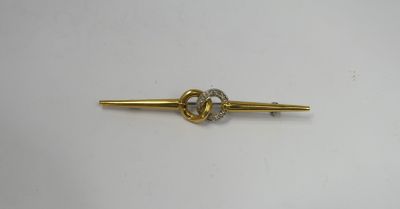 a close up of a gold tie bar with a knot on it
