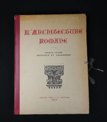 un vieux livre à la couverture rouge posé sur une table noire