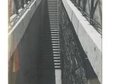 une photo en noir et blanc d'un homme marchant sur un pont