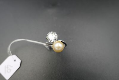 un gros plan d'une bague ornée d'une perle et d'une étiquette