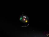bubbles floating in the dark on a black surface with a red and green light