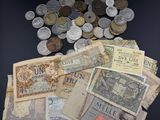 plusieurs billets et pièces de monnaie différents posés sur une surface noire