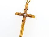 une image représentant une croix en or avec une perle au centre