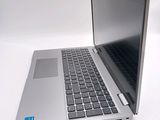 a silver laptop with a black keyboard on a white surface