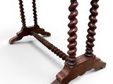 an old wooden table with a curved top and turned legs