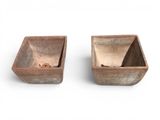 two wooden bowls sitting next to each other on a white surface