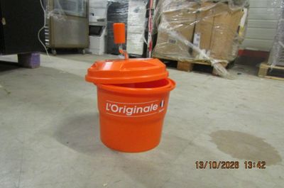 an orange bucket sitting on the floor in a warehouse