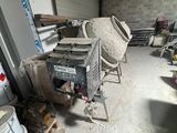 a cement mixer in the middle of a room with a lot of tools