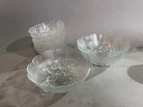 three glass bowls sitting on a table next to each other