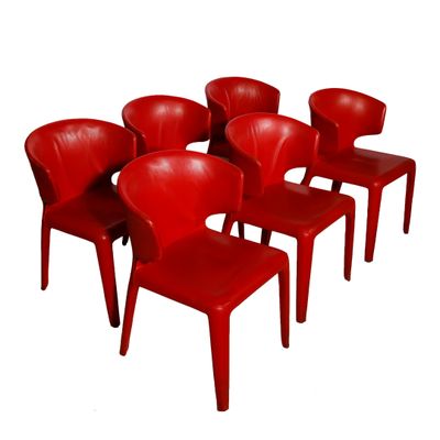 six chaises rouges sont alignées en rangée sur un fond blanc