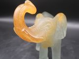 figurine d'éléphant jaune et blanche posée sur un fond noir