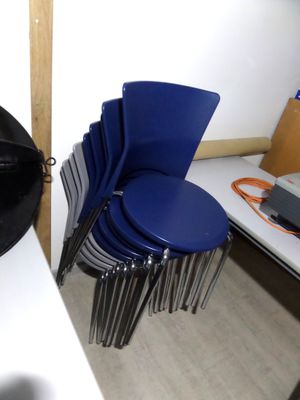 une pile de chaises bleues alignées les unes à côté des autres