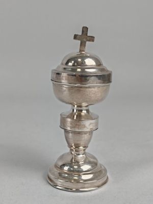 une image représentant une coupe en argent surmontée d'une croix
