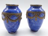 deux vases bleus posés l'un à côté de l'autre sur une surface blanche