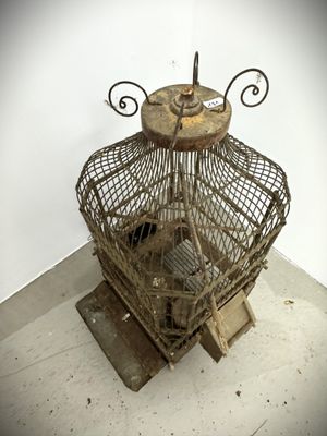 a bird cage that has a bird inside of it